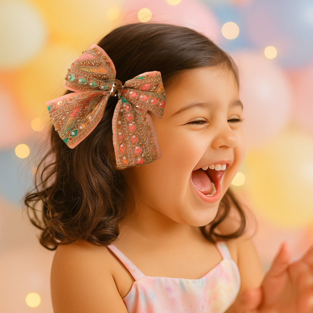 Large peach and gold embroidered bow clip with beads for festive hairstyles.